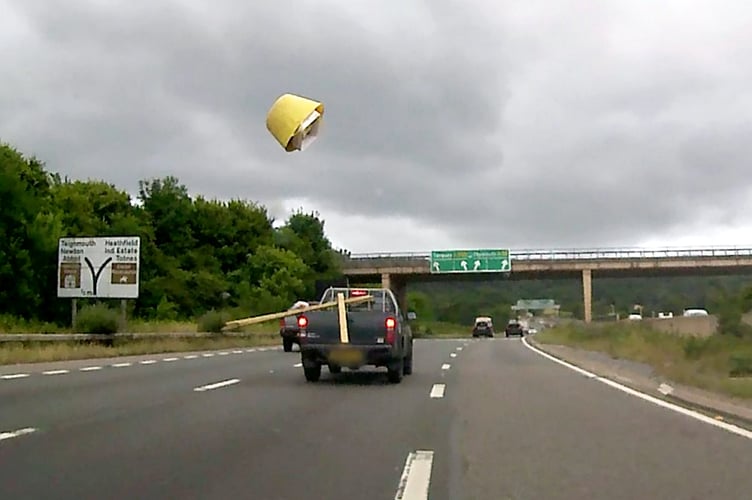 A still from Op Snap footage submitted to Devon & Cornwall Police shows an insecure load flying onto the A38.  This video shows the moment a dangerous driver sent a bucket flying from the back of their van - catapulted by some loose planks.  See SWNS story SWMRtraffic.  The scary moment is one of thousands of clips sent to to police - showing reckless driving in Devon and Cornwall.  They include dangerous overtakes, overloaded lorries and motorists speeding through red lights.  One clip shows a tyre coming loose from a tractor towing a trailer - and being dragged down the carriageway.  In another wooden planks send a bucket flying on the A38 dual carriageway.  A spokesman for Devon and Cornwall Polices Head of Road Safety, said: Both of these incidents could have been far worse and resulted in death or serious injury.'' 