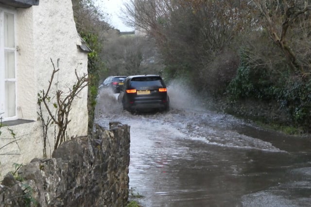 Drivers passing through the flooded road