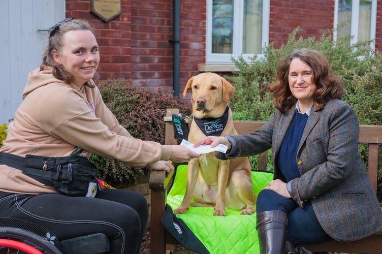 Lisa Moore, Show Manager of the  Devon County Show, presents Chloe Hammond with a £1,000 cheque towards the upkeep of her assistance dog Ocho.