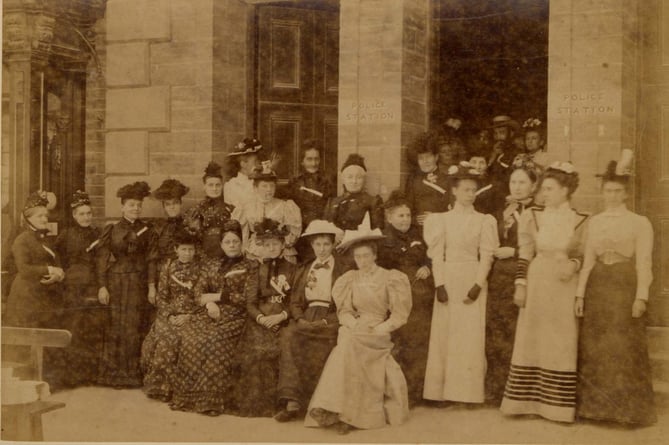 1891 (post) group of women outside Town Hall, Fore Street, Kingsbridge, in best dress.  Note 'Police Station' carved on front.
