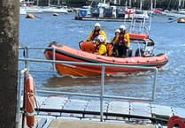 Female stand up paddleboarder helped by the RNLI