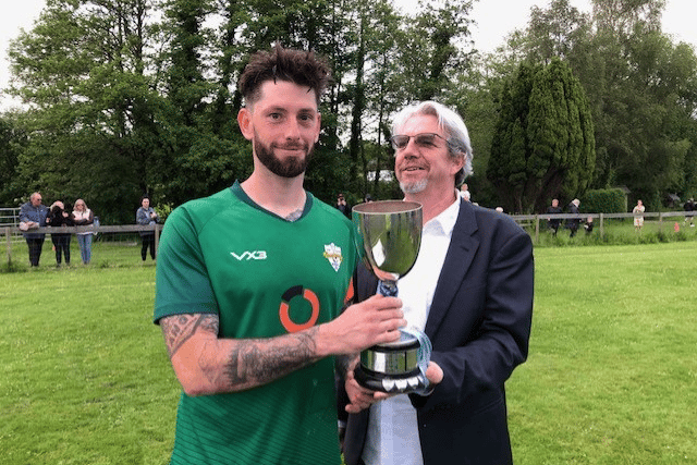 Watcombe Wanderers captain Liam Gatting being presented the Ronald cup by sponsors Ashley Williams of Coast and Country Estate Agents