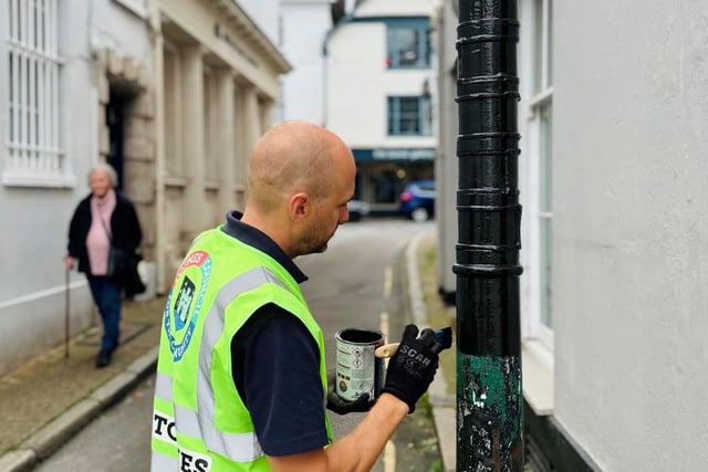 Neil paints bollard protecting special building in Totnes