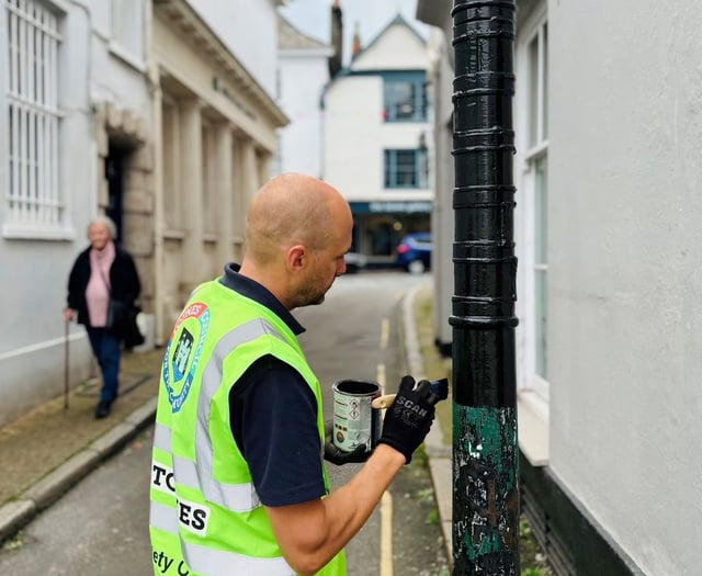 Neil paints bollard protecting special building in Totnes