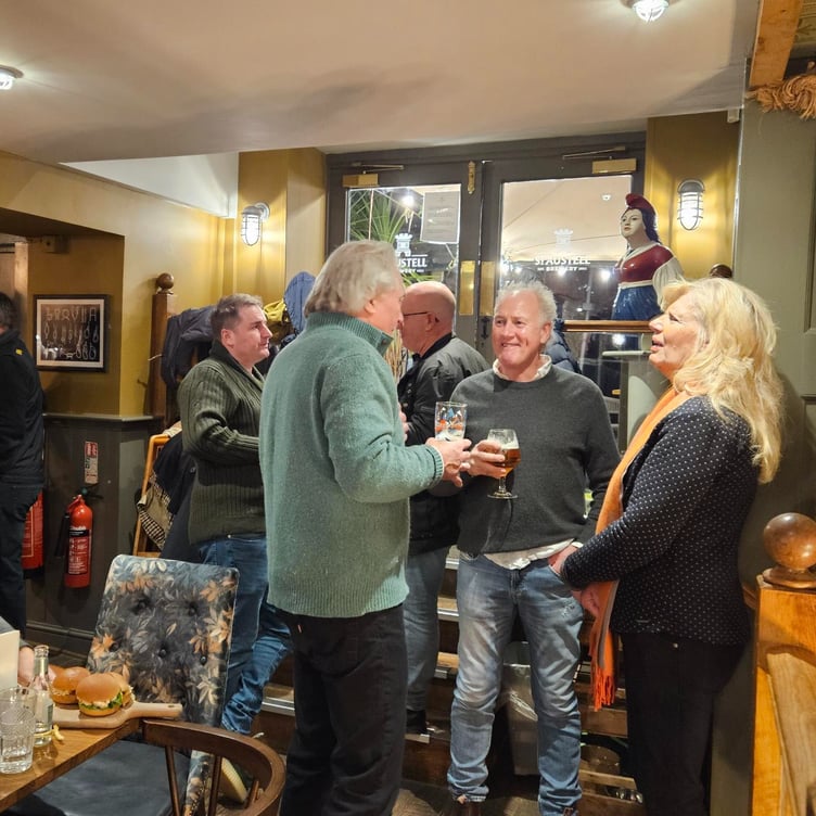 Salcombe Mayor Cllr Mark Goodey joins RNLI team members and others to toast the switch of The Field of Light