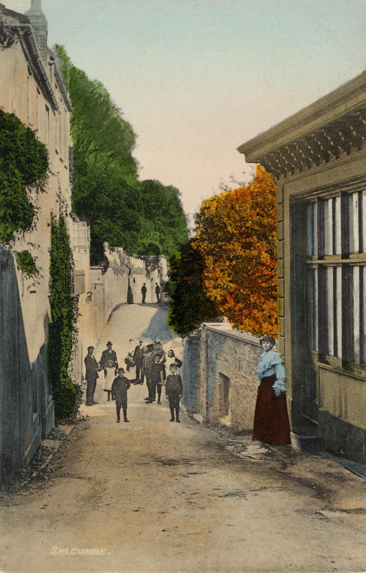 Around 1900 Cliff Road, Salcombe, at Baker*s Well, view from the southern end. Cliff House is at rear left. Children standing in road, young lady in doorway of house on right.