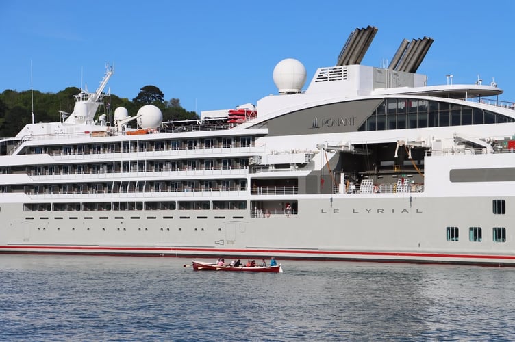 Rowers dwarfed by the cruise ship