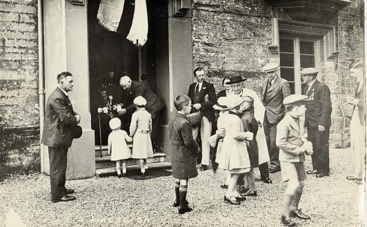 Vicar of Aveton Gifford greeting children on occasion of Silver Jubilee 1935. Children being given commemorative mugs. 