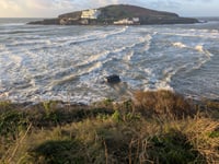 Person rescued after car swept into sea