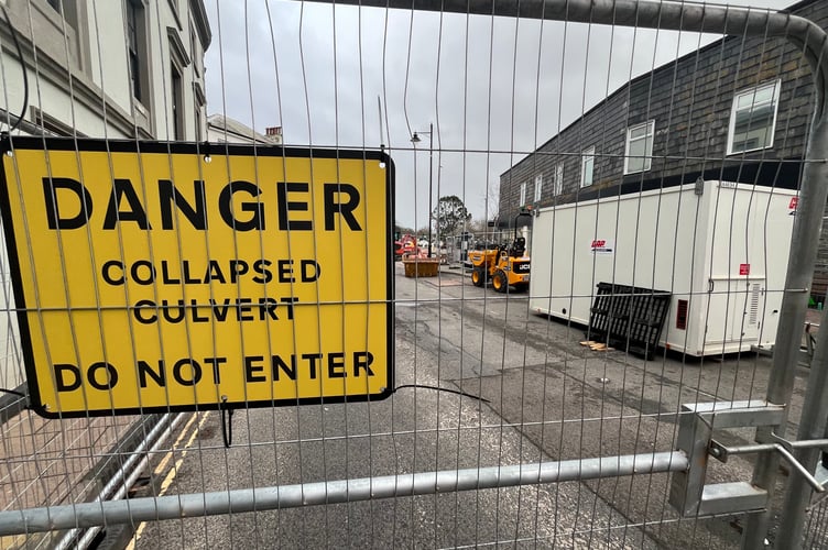 Fencing and warning signs at the site of the hole and collapsed culvert in Fore Street, Kingsbridge