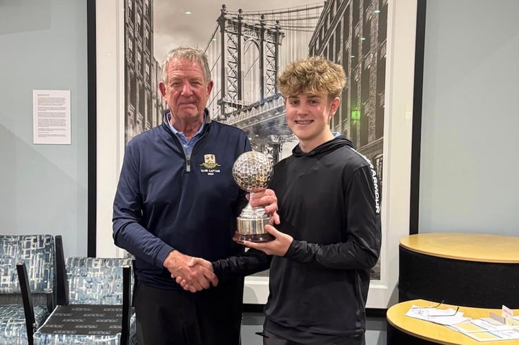 captain John Rogers presents the trophy to juniors captain William Hoskin