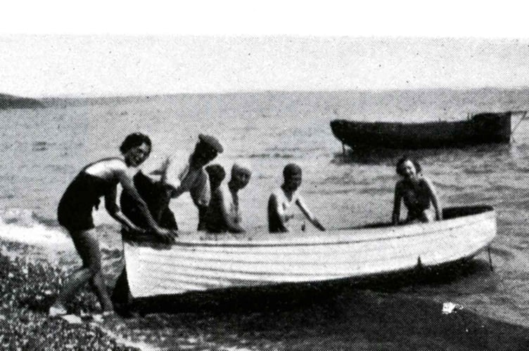 Trouts Hotel at Hallsands, run by the two sisters Patience and Ella Trout. 
Man helping ladies in swimming costumes to launch a small boat