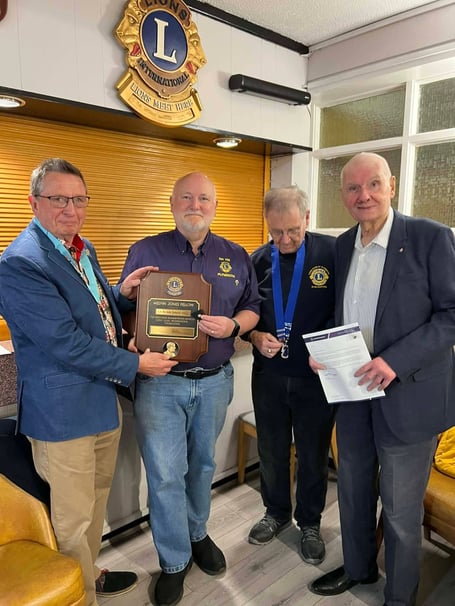 Lion Phil Bunt presenting 50-year service chevron to Graham Hambly at Plymouth Lions Club