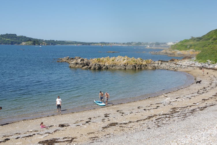 A warm day with an unbroken blue sky brought people out onto the small beach.