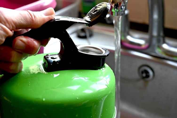 Kettle being filled at kitchen sink