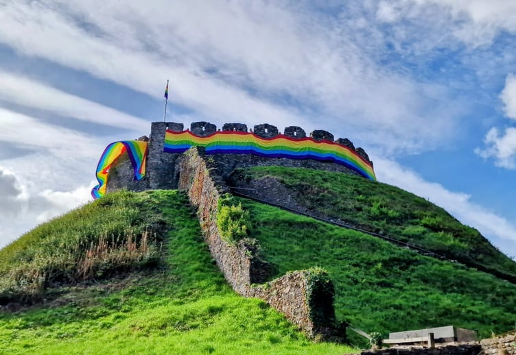 Totnes Castle wrapped in a 150-mitre flag for Totnes Pride.