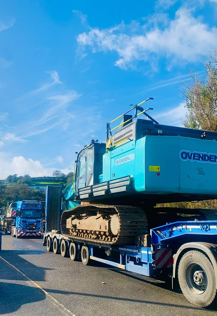 Trucks arrive with machinery to start building rock armour sea defences at Torcross.